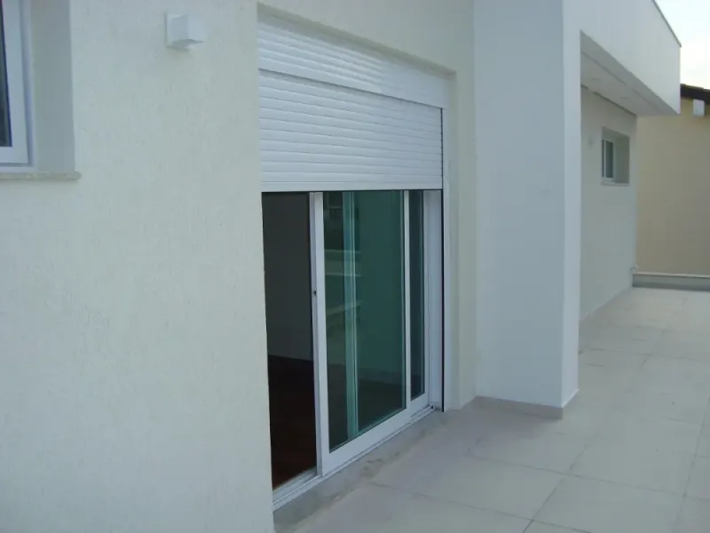 Porta de correr de alumínio branco com persiana integrada instalada pela Imperium em Maringá